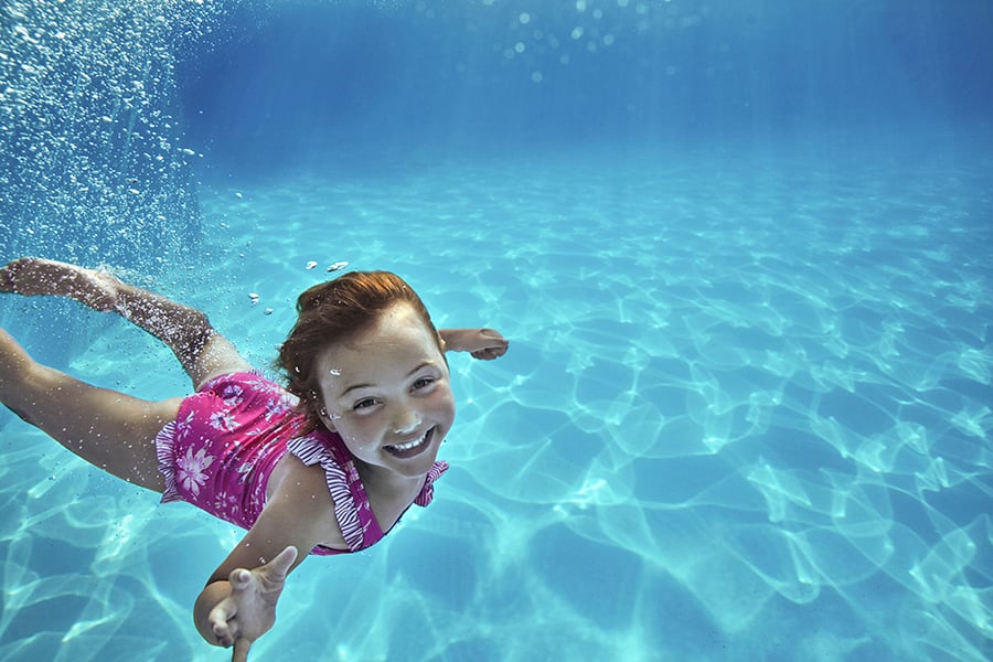 Barn dyker i pool under resa på sportlovet
